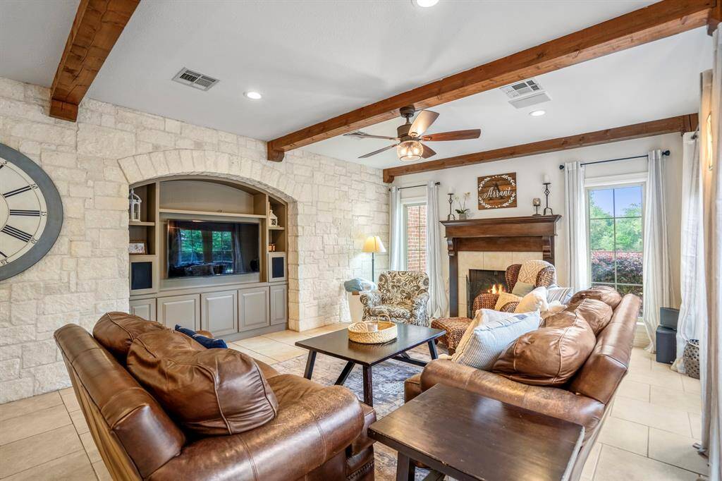 The sitting room features a charming fireplace and elegant beamed ceilings.