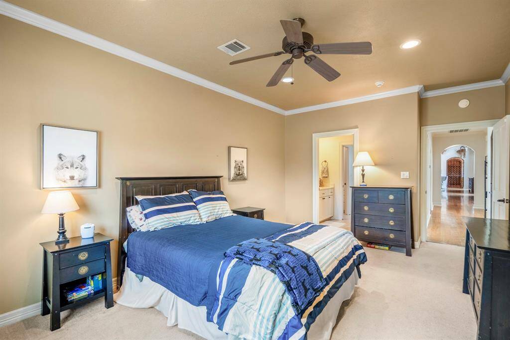 Carpeted Secondary Bedroom with crown molding, a ceiling fan and an en-suite Bathroom.  This bedroom has an entrance off the front terrace and could easily serve as a mother in law suite.