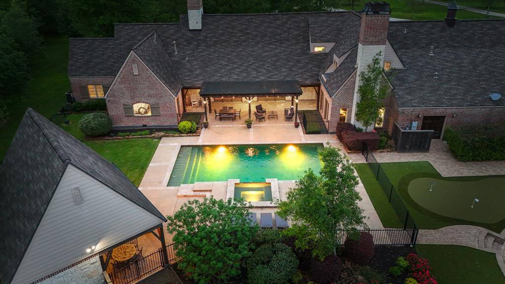 The possibilities are endless in this backyard space! Pool, outdoor kitchen, covered patio, fire pit and custom putting green