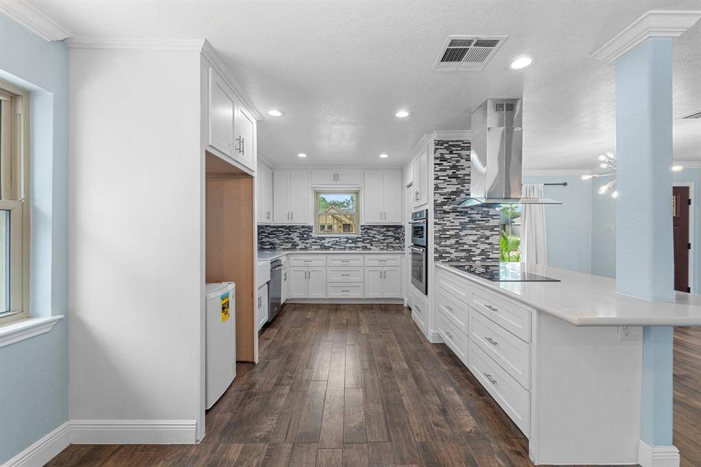 This remodeled kitchen is open to the dining area, featuring beautiful white cabinetry, stainless steel appliances, granite countertops, a breakfast bar, and much more. This kitchen has a fantastic layout and is very spacious.