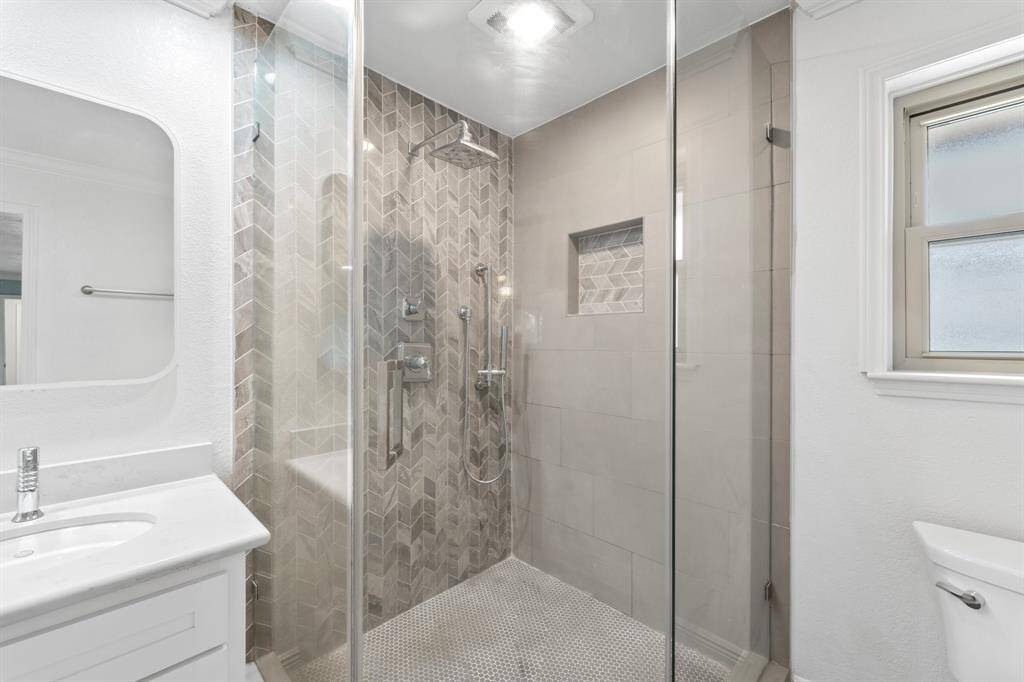 It is complete with an elegant glass enclosed shower and beautiful tiling.