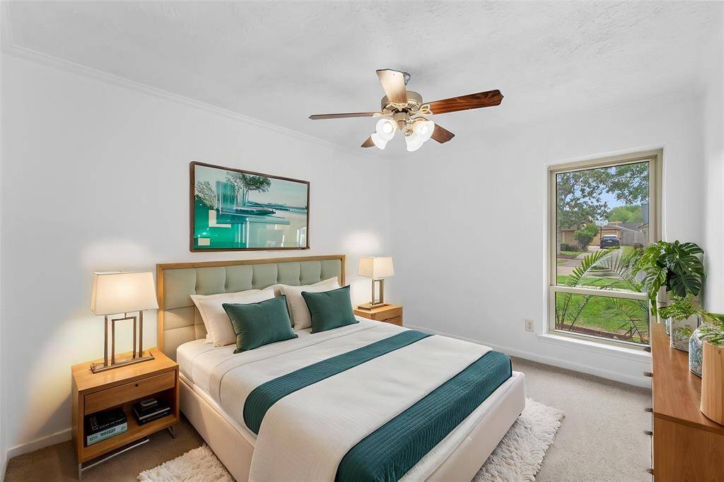 Virtually Staged: Stunning Secondary Bedroom featuring neutral colors, carpet floor, a ceiling fan, and a large window.