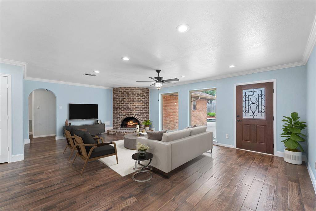 Virtually Staged: This stunning living room boasts high ceilings with recessed lighting and a ceiling fan, beautiful wood tile floors, a stunning stone fireplace, large windows providing a beautiful view of the backyard and tons of natural light in throughout the day!
