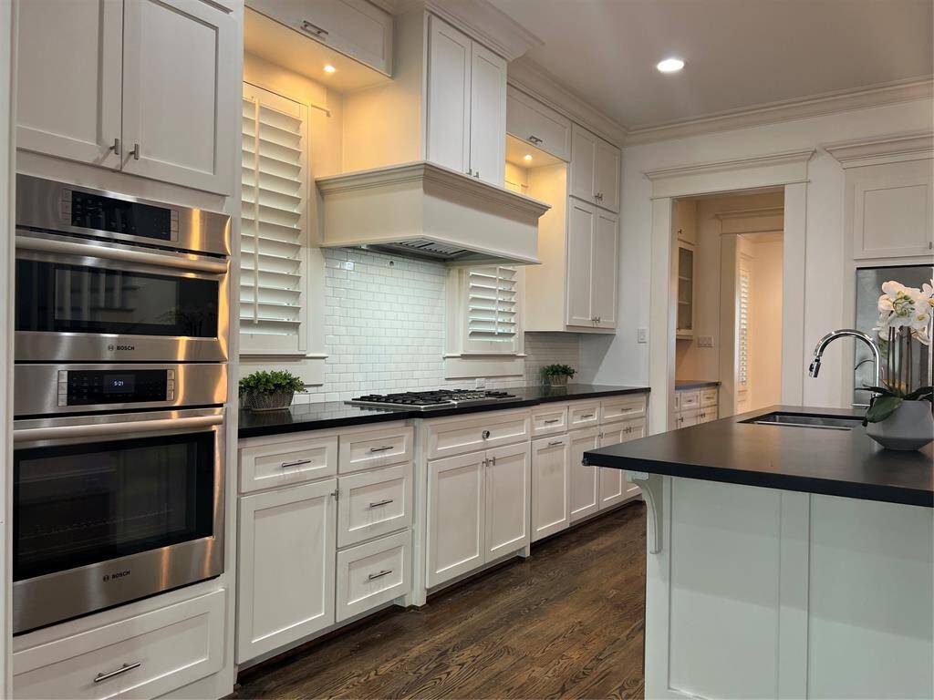 Plentiful with storage, double oven, gas cooktop black stone countertop.
