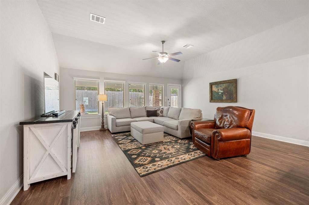 The living room extends the ranch style aesthetic with a Native American-style rug, which adds a vibrant touch. The space is furnished with wooden furniture that exudes a rustic charm to the beautiful space.