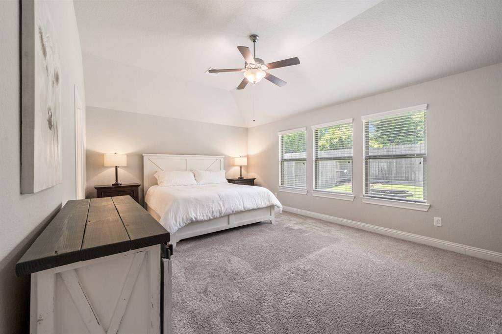 The primary bedroom is a spacious retreat featuring soft carpeted floors and abundant natural light that creates a warm, inviting atmosphere. It also includes a beautiful, well-designed closet offering ample storage and comfort.