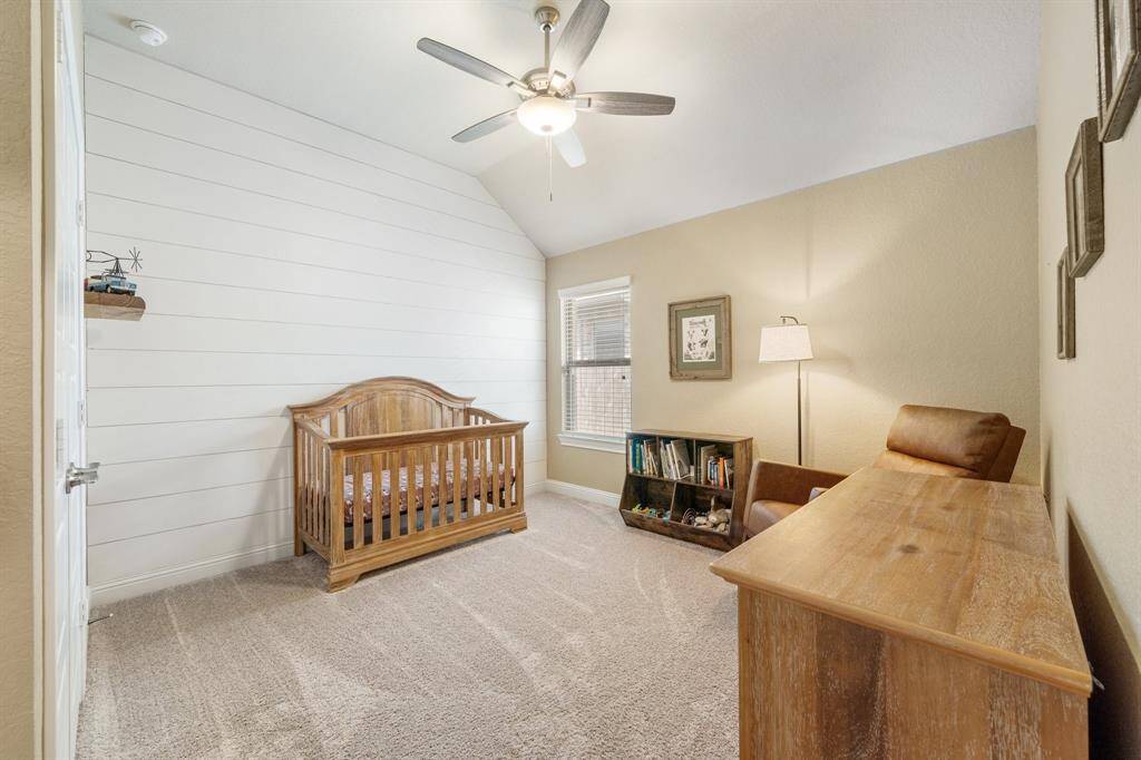 A shiplap accent wall and neutral tones create a serene and welcoming atmosphere in this room. A peaceful retreat corner in the house, perfect for both rest and play.