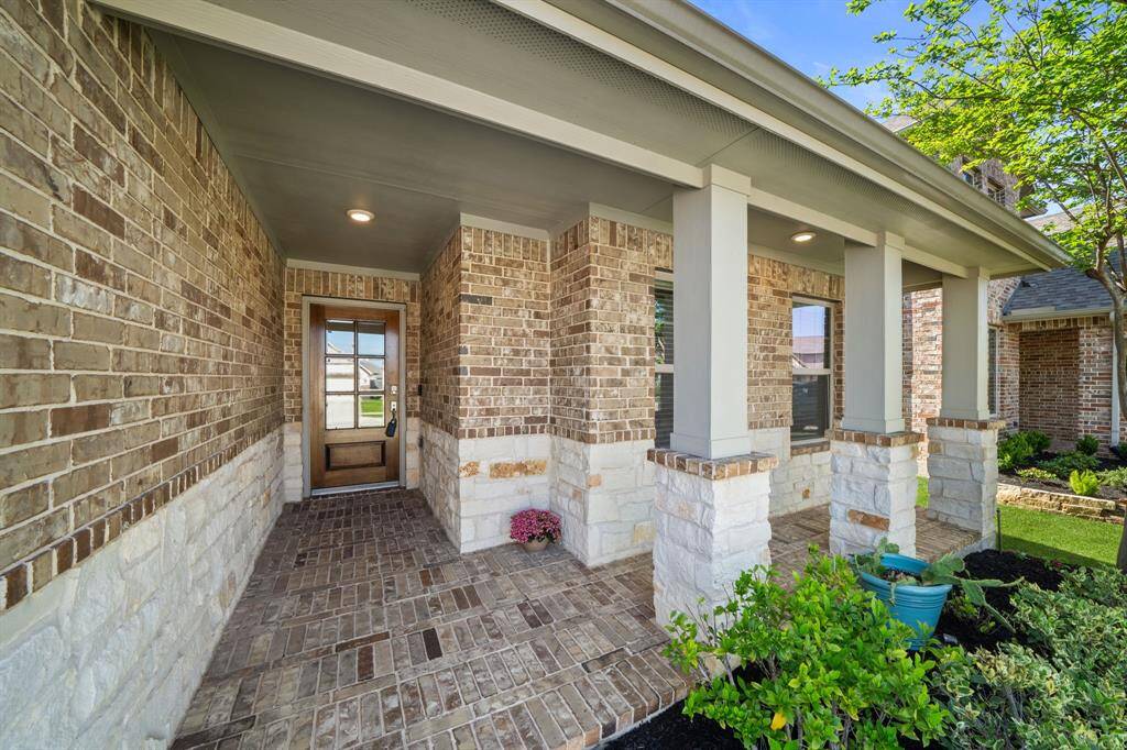 Front porch provides a covered design, giving shelter and a welcoming entryway to its visits and occupants. Its brick exterior and clean lines complement the home's classic ranch-style aesthetic.