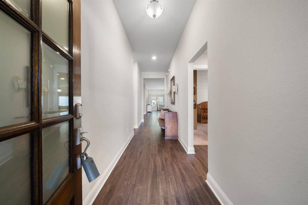As soon as you enter the house, you are welcomed by a striking dark wood aesthetic, featuring rich dark wood furniture and matching dark wood vinyl flooring.