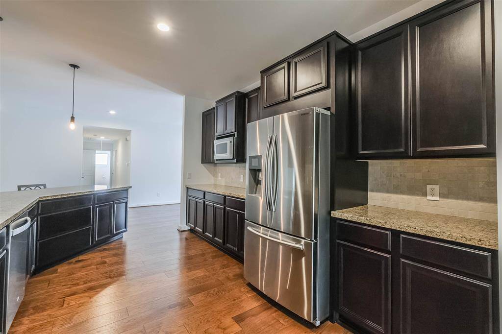 Counter space is abundant.  Notice the pots and pans drawers and the pendant lights.  Drawers have soft close rollers.  The refrigerator is 1 year old (per seller).