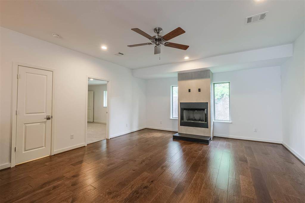 Gas fireplace anchors the family room with connections for a TV.  The open doorway to the left is a secondary bedroom/guest bedroom or study with its own full guest bath