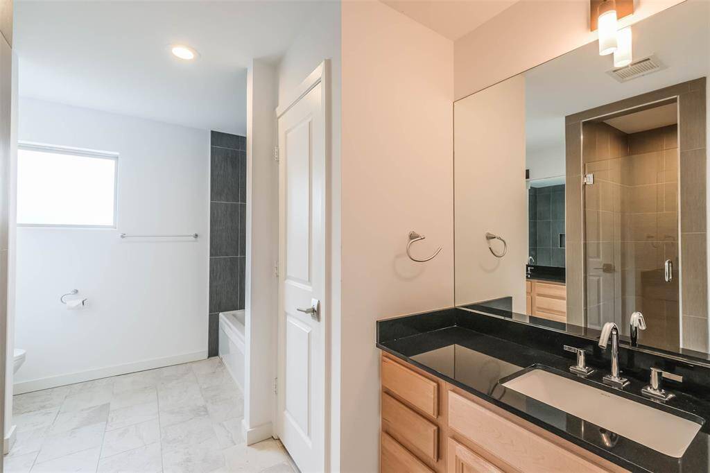 Primary bathroom offers a jetted tub and a stand-up shower and two separate sink areas