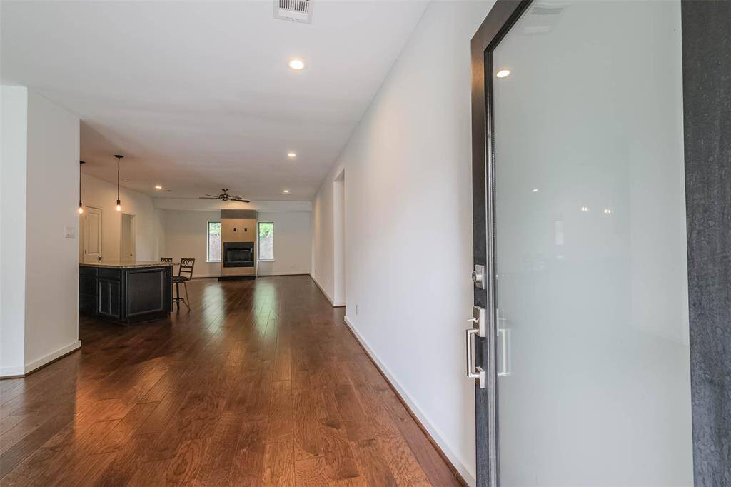 The modern front door leads into a wide foyer with beautiful engineered wood floors. The sight lines are unobstructed and welcoming.