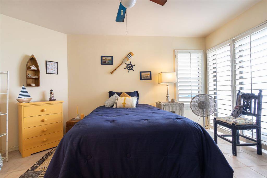 First floor bedroom with patio doors to the right. Plantation shutters. There is an ensuite bath.