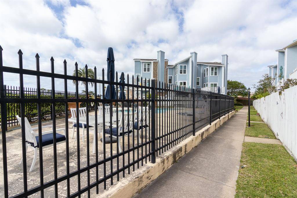 Walkway inside the condominium compound with fenced pool area on the left.