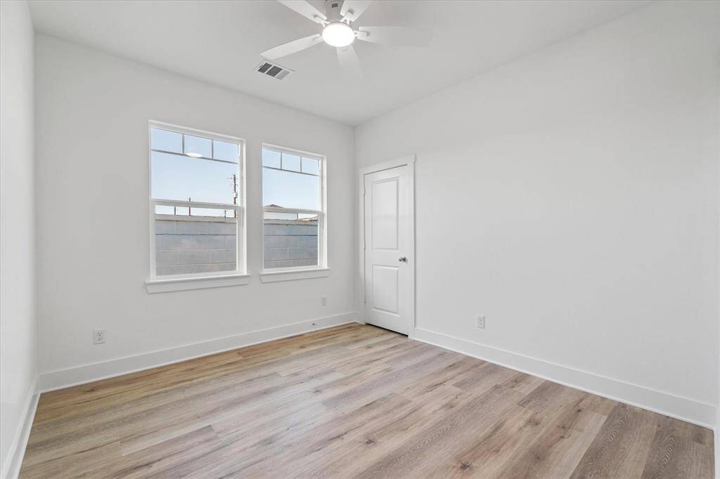 The second full bathroom upstairs features a shower-tub combo, black & white tile reaching the ceiling, a handy soap niche, chrome fixtures for a modern touch, and extra storage with a cabinet above the toilet.