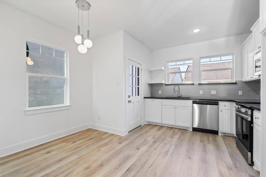 This thoughtfully designed kitchen includes custom cabinets, chrome hardware, a gray subway tile backsplash, stainless steel appliances, recessed lighting, and a roomy pantry!