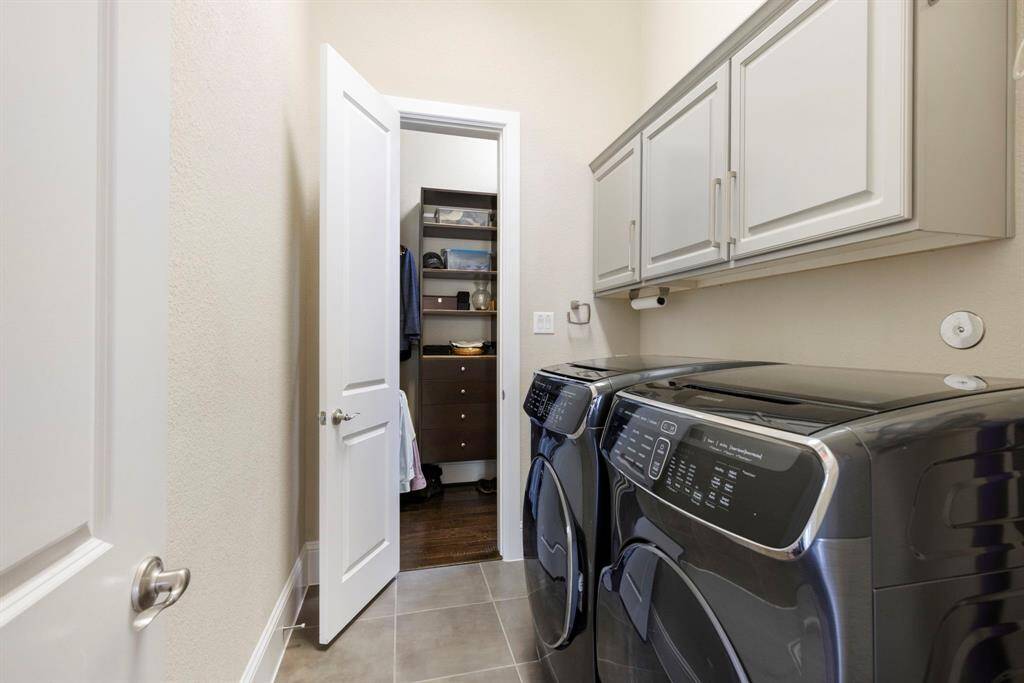 Huge his and her closet space with a large laundry room with a sink adjacent to the primary closet.
