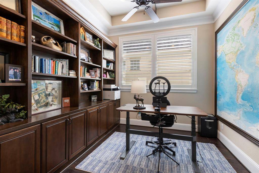 Custom built-in bookshelves to the left and a statement world map on the right.