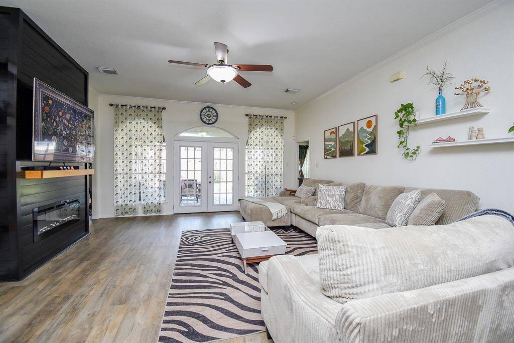 Spacious living room with modern fireplace and a bright double-door patio entry.