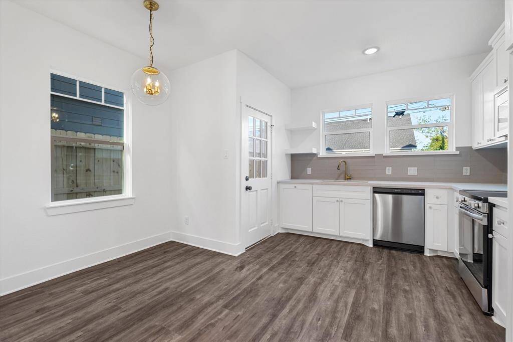 Dining area with bay windows and a striking gold light fixture.