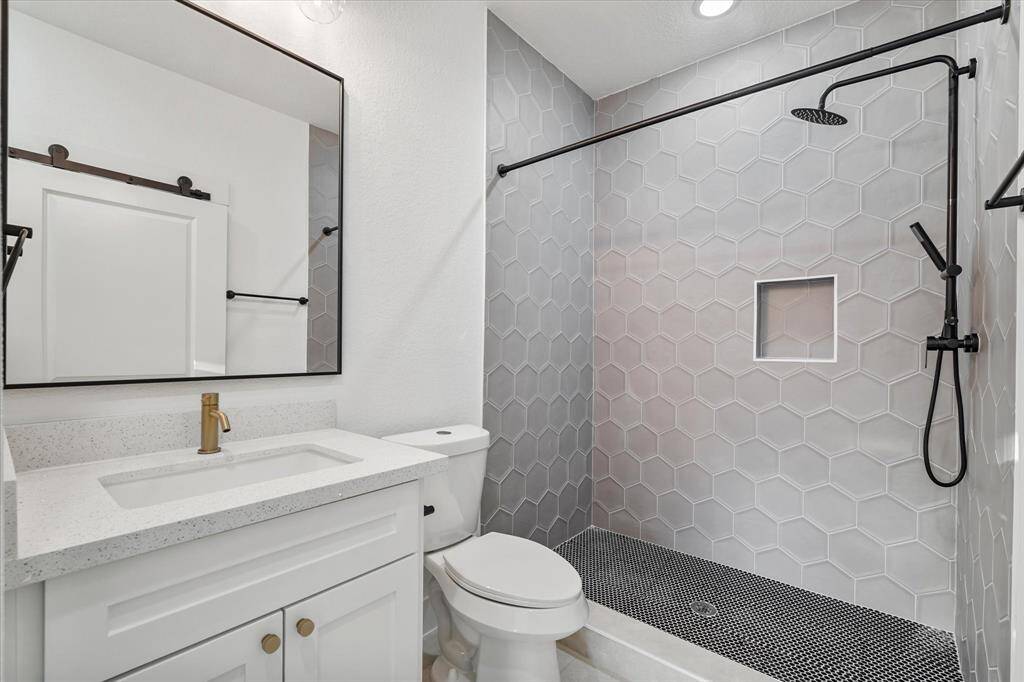 Second-floor primary bedroom with luxury vinyl flooring, ceiling fan, recessed lighting, and a private en suite bathroom.
