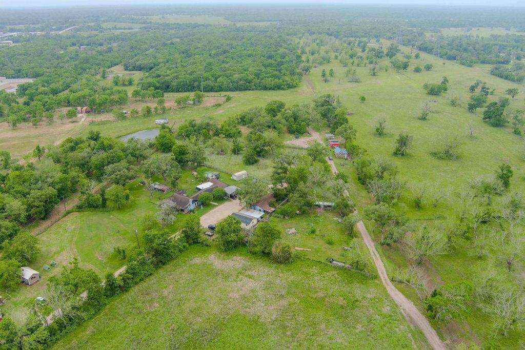 The road into the 20 acre lot. Partially cleared, fully fenced. The property starts closer to the red building seen on the right side.