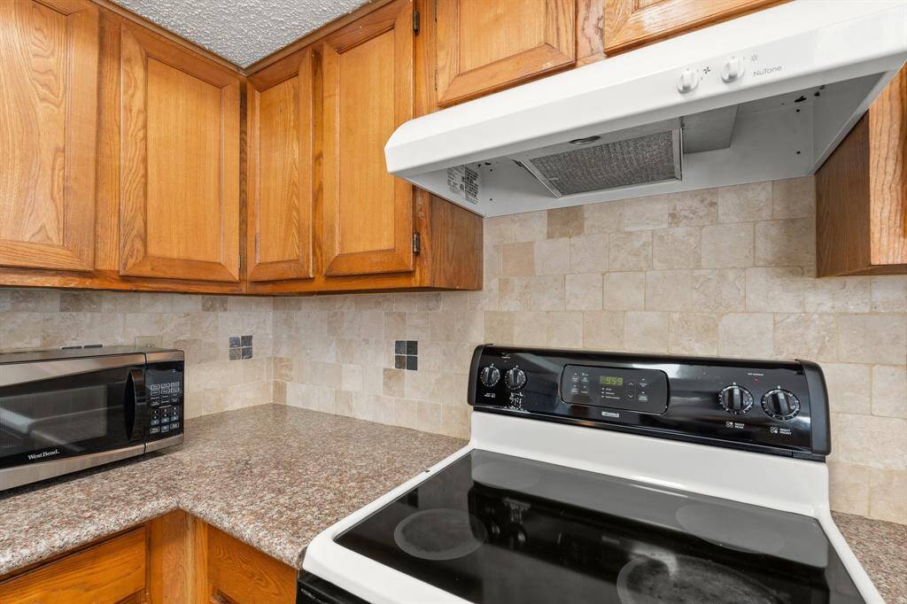 An additional view of the Gourmet Kitchen featuring warm cabinetry, abundance of storage, breakfast bar for additional seating and Stainless Steel appliances.