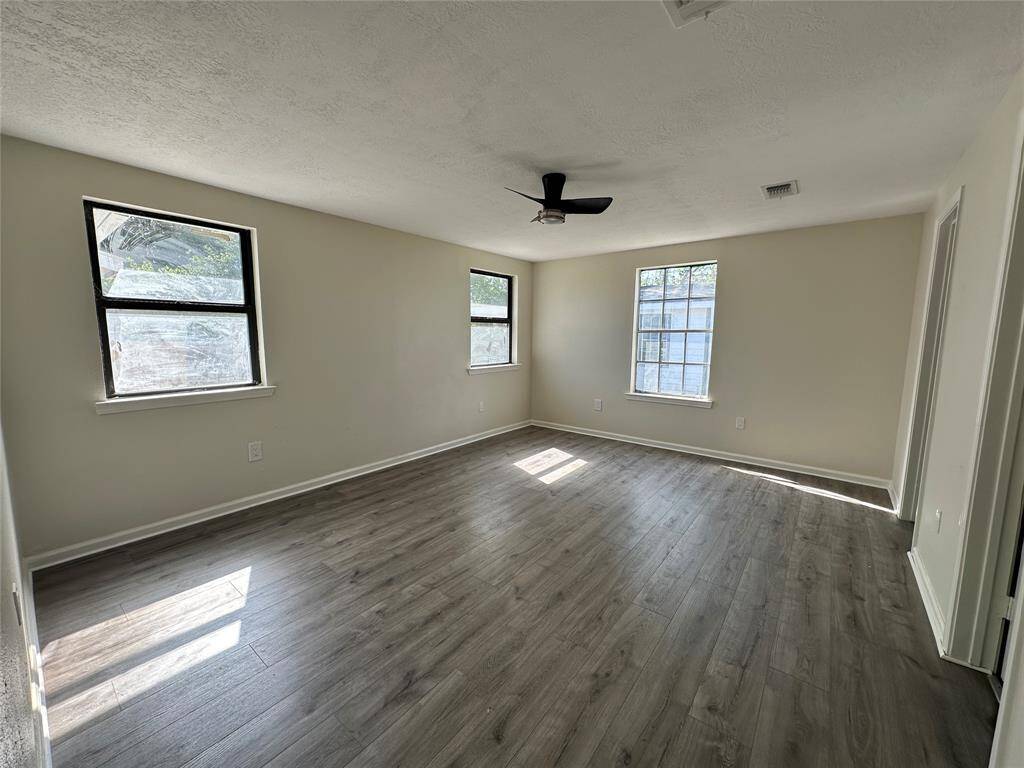 Spacious primary bedroom featuring elegant flooring, abundant natural light, and a convenient layout with large closet.