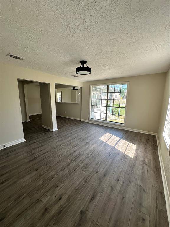 Bright and inviting living room with large windows, elegant flooring, and modern lighting—perfect for relaxation and entertaining.