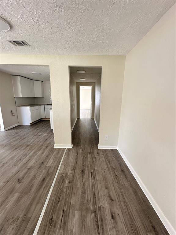 Welcome to a spacious, light-filled entryway featuring elegant flooring, modern ceiling fan, and a large window for natural light.