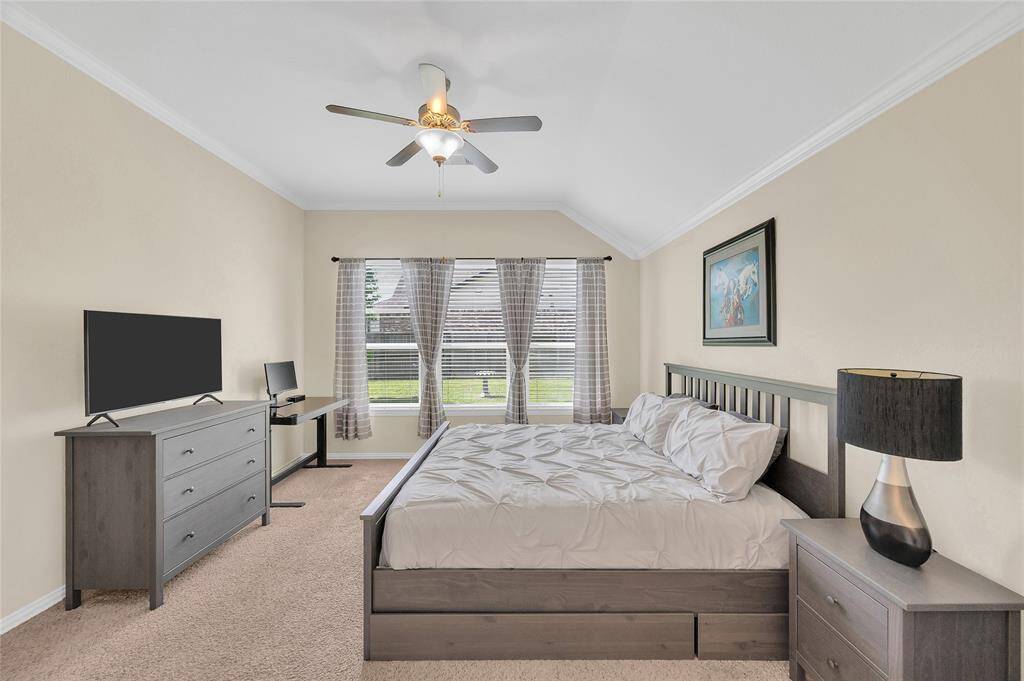 Spacious primary bedroom suite with a wall of windows and vaulted ceilings.