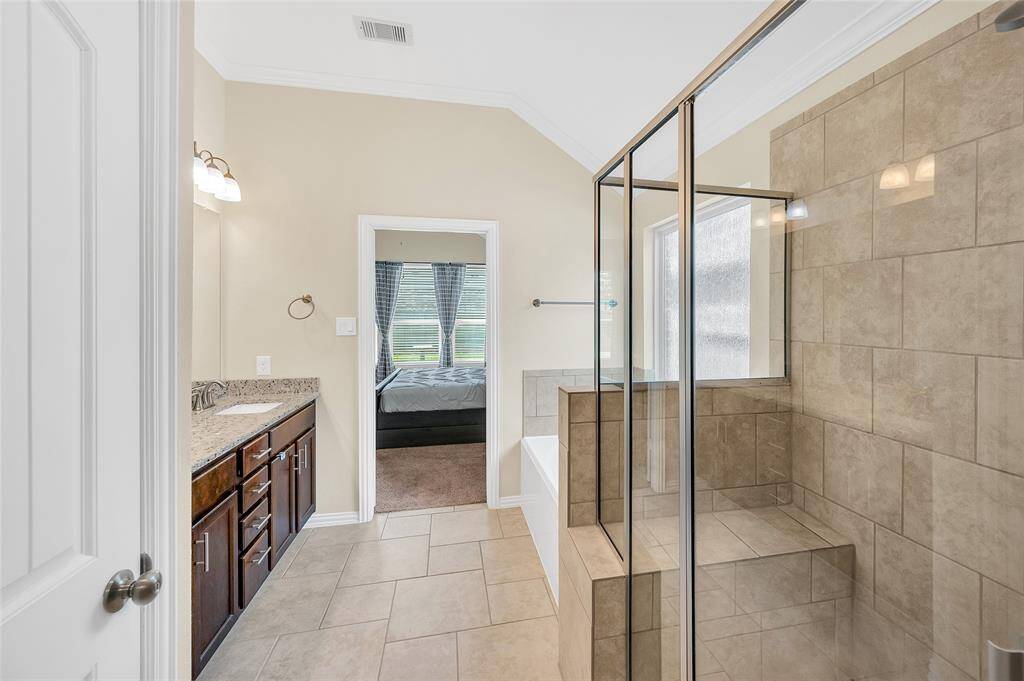 Spacious walk-in shower with custom bench seating and tile shower surround.