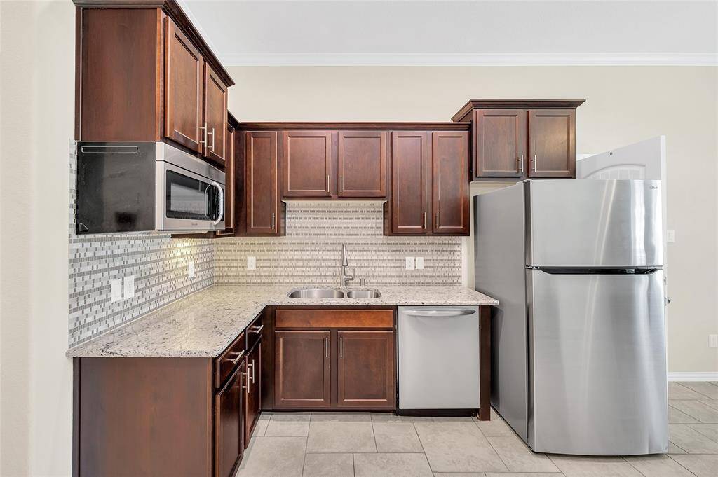 The stainless-steel microwave, dishwasher, and refrigerator are included.