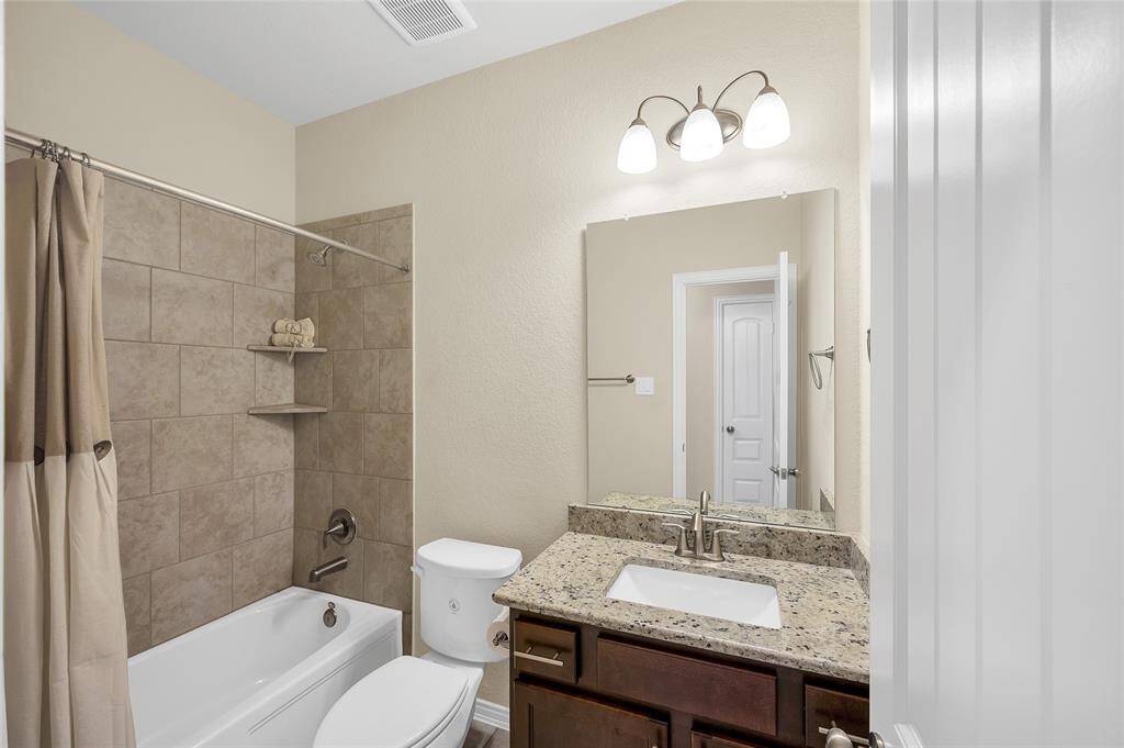 Main floor guest bathroom with tile tub surround and granite tops.