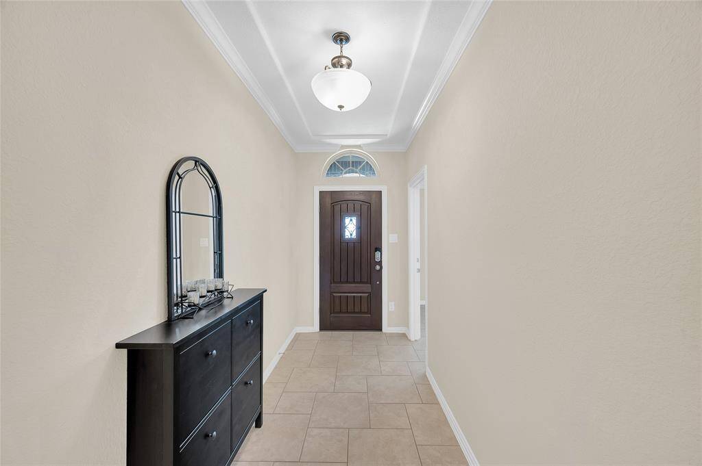 Grand foyer with arched window over the door front door.