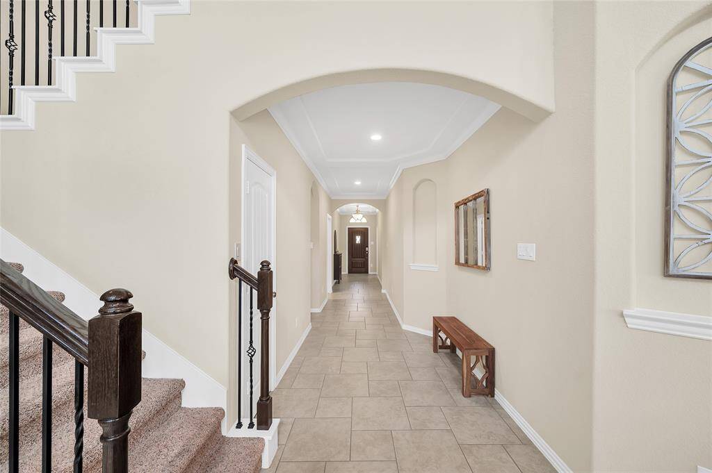 Stunning entry with custom ceiling details, arched entries, and arched niches.