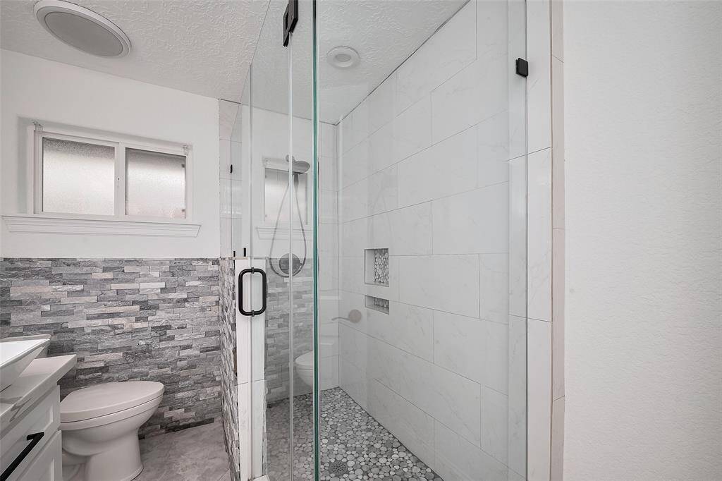 Renovated standing shower in the secondary restroom