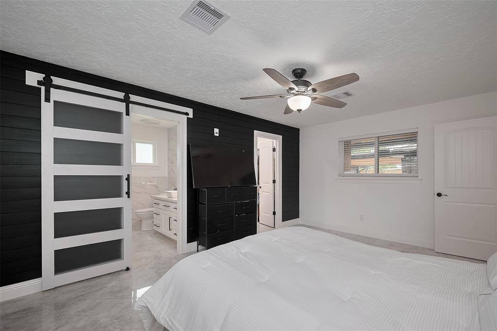 Primary bedroom with a barn-style door with frosted glass paneling leading to the Bathroom
