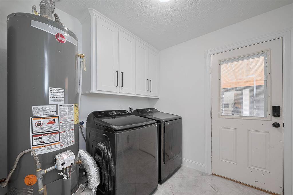 Utility room featuring a brand new water heater, washer, and dryer!