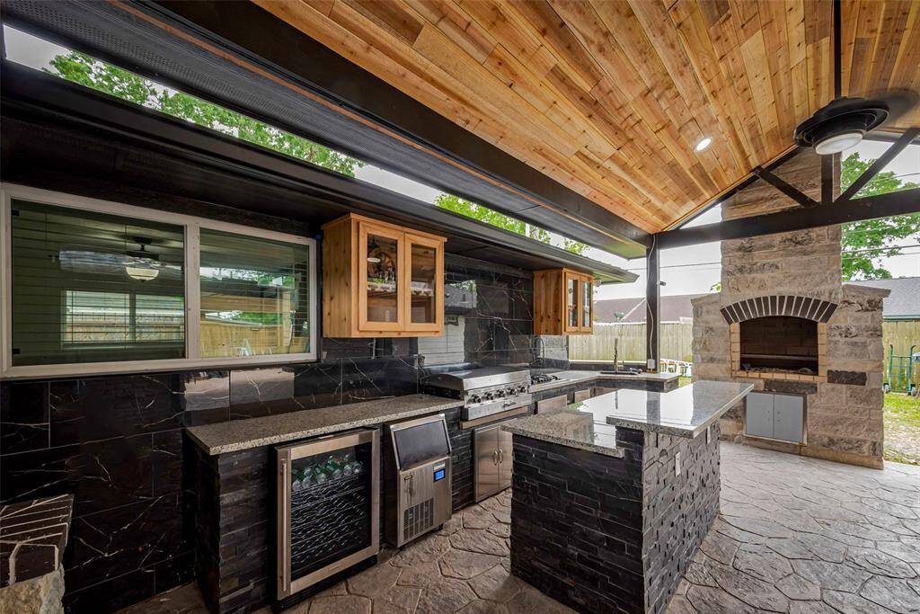 The outdoor kitchen comes with a mini fridge/wine cooler, grill, gas cooktop, ice maker, and a pizza oven!