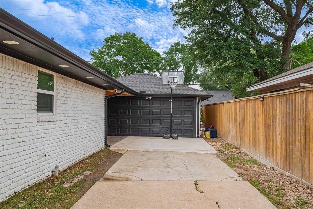 Extended driveway space leading to the garage with new side fence