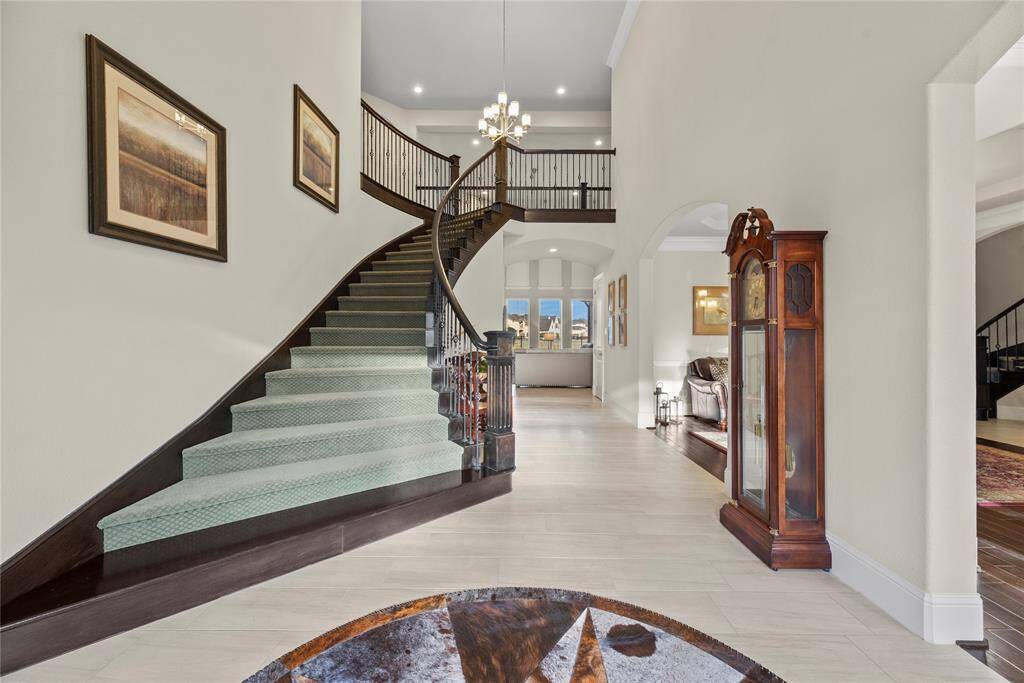 Step inside and be greeted by a show-stopping curved staircase that instantly sets a tone of elegance and sophistication. This architectural centerpiece adds a grand touch to the foyer, beautifully blending style and craftsmanship as it leads you into the heart of the home.