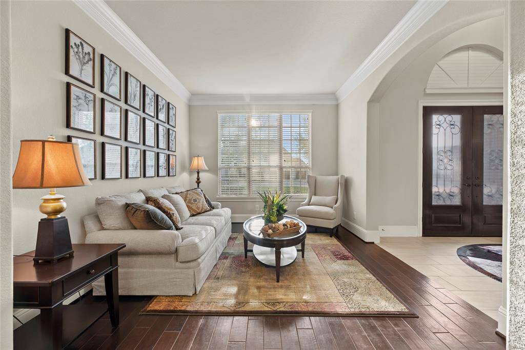 Just to the right of the entry, the formal living area welcomes you with timeless charm and graceful design. Perfect for intimate gatherings or quiet moments, this sophisticated space sets the tone for the refined living found throughout the home.