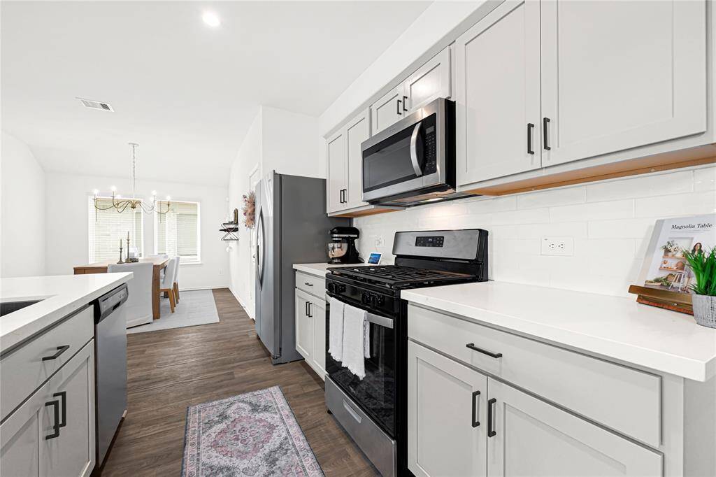 Upgraded kitchen with quartz countertops, backsplash, and new kitchen sink.