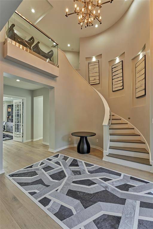 The two-story foyer entails elegance and sophistication with it's spiraling staircase and second floor glass wall encasing.