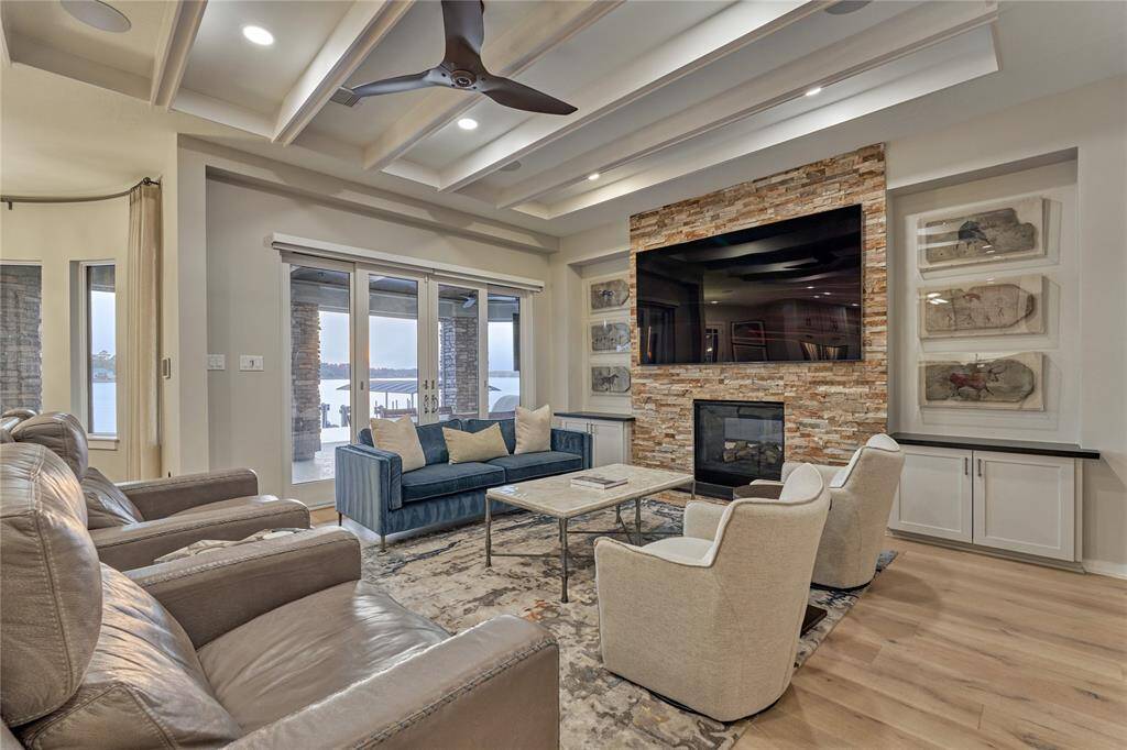 The family room features a stacked-stone, floor-to-ceiling fireplace flanked by custom built-in storage. Clean lines and a neutral palate create a calm and peaceful ambiance.
