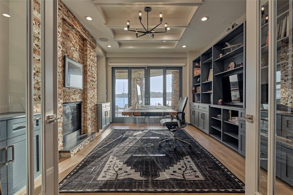 And the luxurious features continue to impress as found here in the executive study. One feature wall boasts of a stacked stone gas fireplace and the back wall features built-in cabinets and shelving. This work space is truly inspiring, especially with captivating lake views just outside your windows!