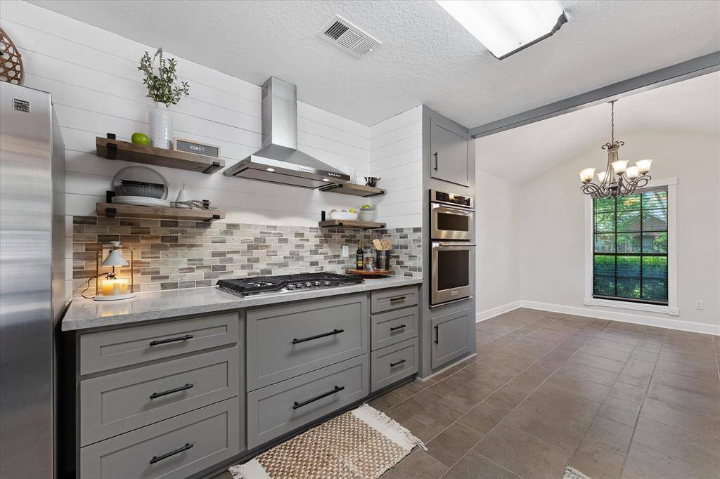 Experience modern kitchen upgrades with a sleek, newly installed exterior-vented hood and stylish floating shelves added in 2021.