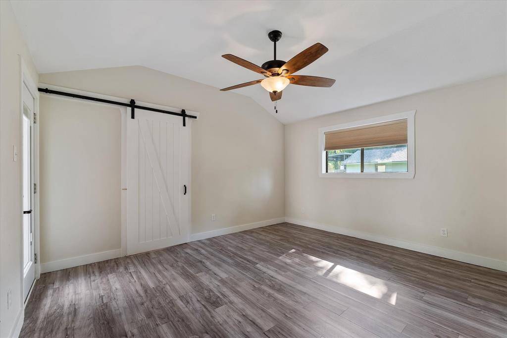 Experience elegance in the primary suite with a stylish barn door leading to the ensuite bathroom.